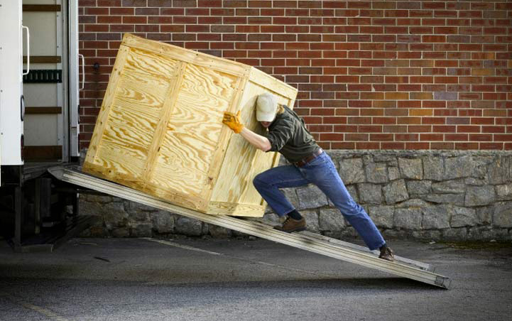 man pushing a crate up a ramp